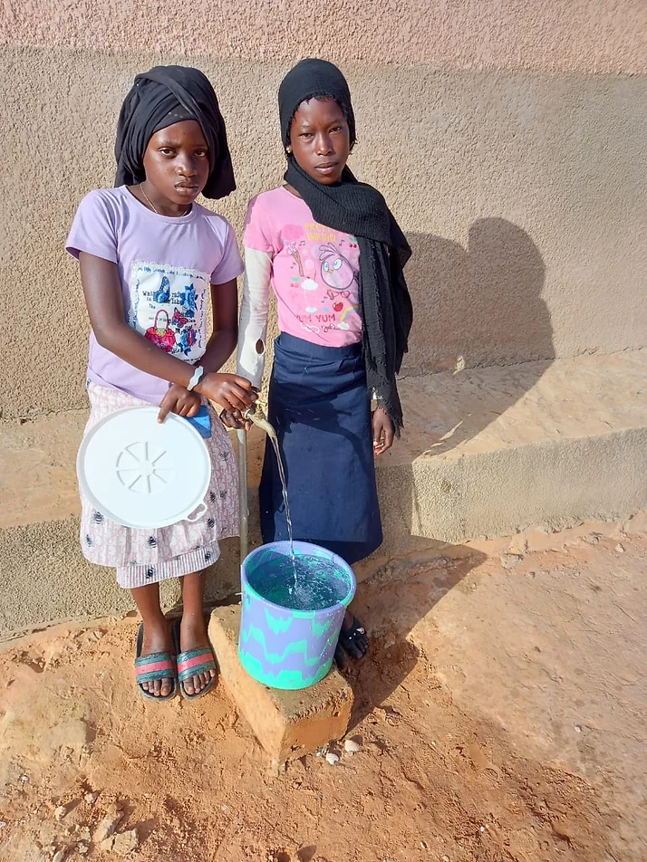Deux jeunes filles de l'école près du puit