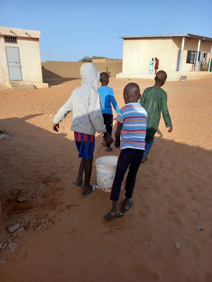 Enfants amenant de l'eau récupéré au puits